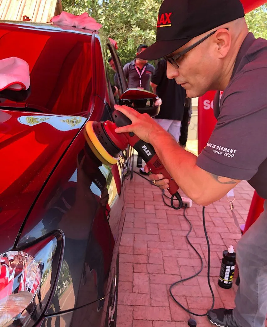 Technician machine-polishing a body panel