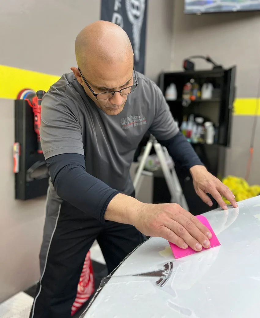 Protective film being worked across a body panel